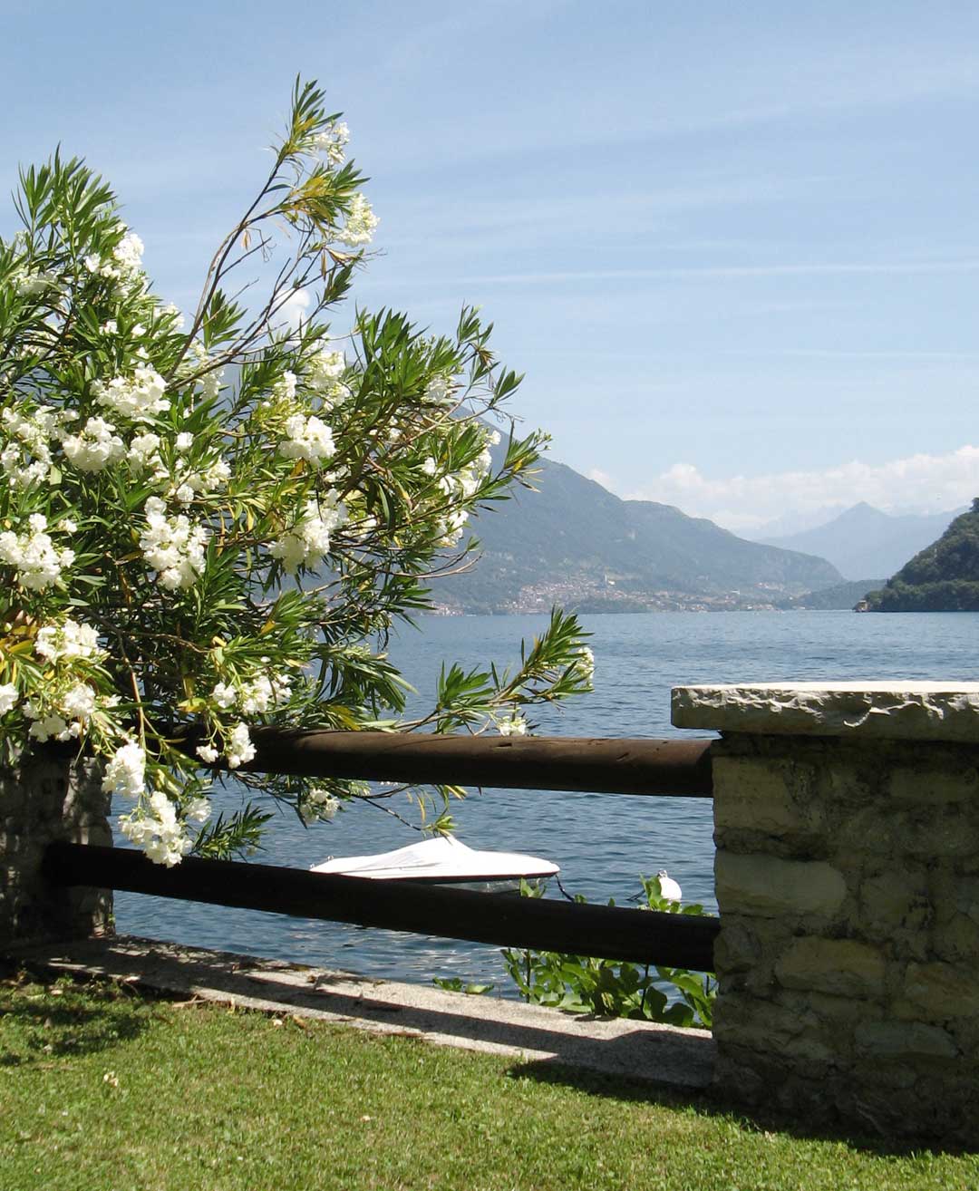 Private lakeside relaxation area surrounded by greenery with views across Lake Como.