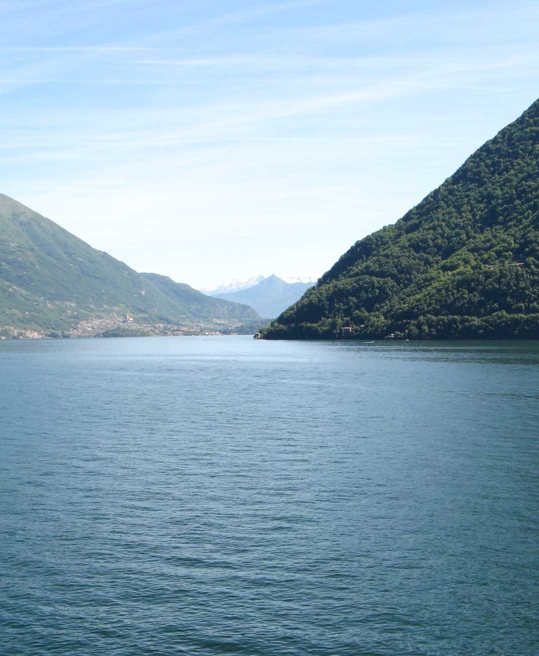 Panoramic view of Lake Como from the private Telos Boats dock in Brienno, the exclusive starting point for your boating experience.
