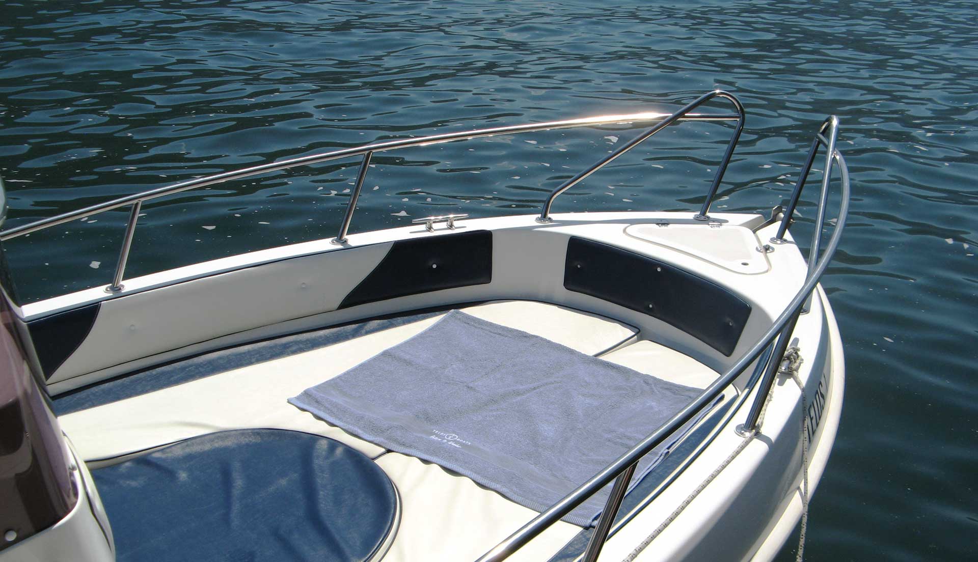 Sun deck with comfortable cushions and a dedicated towel aboard a Telos Boats rental boat.